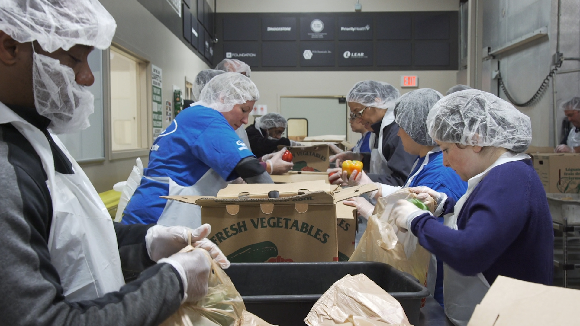 Volunteers pack food at the Forgotten Harvest Warehouse