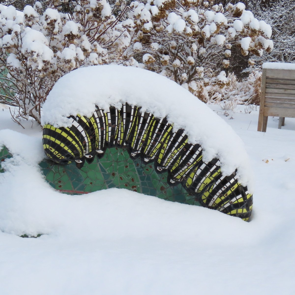 snow-covered caterpillar statue in garden