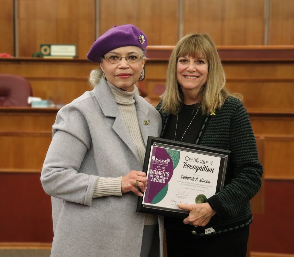 Two women stand together holding a plaque.